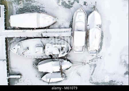 27 février 2018, l'Allemagne, à Kirchdorf (Poel) : Bateaux à voile sont entourés de glace dans le chantier naval Port de Kirchdorf île de Poel, sur la mer Baltique (vue aérienne avec un drone). Le gel permanent avec des températures nocturnes en vertu de moins dix degrés sont lentement de givre dans les baies le long de la mer Baltique. Photo : Jens Büttner/dpa-Zentralbild/dpa Banque D'Images