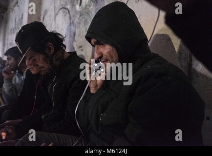 Sid, la Voïvodine, Serbie. 10 fév, 2018. Dans une usine abandonnée près de la frontière croate, serbe - une réfugiée de l'Afghanistan parle avec la famille retour à l'accueil.sid est une ville et une municipalité située dans le district de Syrmie, la province autonome de Voïvodine, en Serbie. La ville de Sid est situé directement à côté de la frontière croate - Serbe. La route des Balkans a été officiellement fermé il y a plus d'un an avec la Croatie et la Hongrie la sécurisation des frontières qui a conduit aux migrants et aux réfugiés de se coincer en Serbie. Bien que les bordures autour de la Serbie ont serré il y a encore tenté bord Banque D'Images