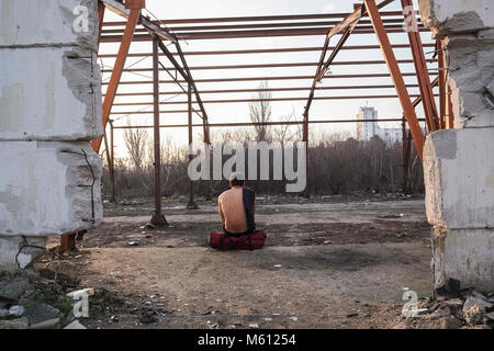 Sid, la Voïvodine, Serbie. 10 fév, 2018. En dehors d'une usine abandonnée près de la frontière croate, serbe - migrants pakistanais se détend dans le soleil de l'après-midi. Le jeune homme affirme avoir été forcé de quitter le Pakistan à cause de la violence des talibans près de son village.sid est une ville et une municipalité située dans le district de Syrmie, la province autonome de Voïvodine, en Serbie. La ville de Sid est situé directement à côté de la frontière croate, serbe -.La route des Balkans a été officiellement fermé il y a plus d'un an avec la Croatie et la Hongrie la sécurisation des frontières qui a conduit aux migrants et réfugiés Banque D'Images