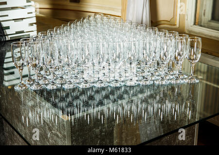 Ensemble de verres vides disposées en triangle sur fond miroir sur banquet service traiteur Banque D'Images