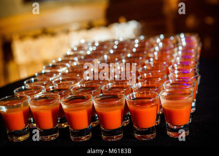 Ensemble de verres avec du jus d'orange disposés en rangées sur le noir sur la table de banquet service traiteur Banque D'Images