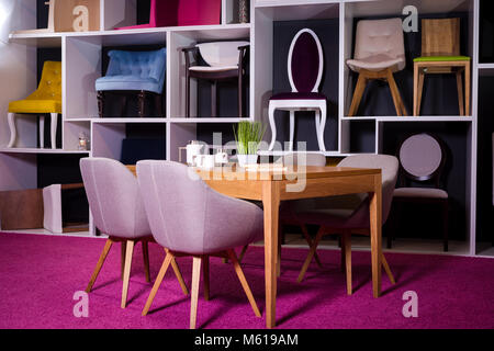 Boutique, vente de meubles dans un centre commercial. Échantillon d'exposition coin table en bois avec chaises textile en gris sur un plateau blanc avec mobilier et un Banque D'Images