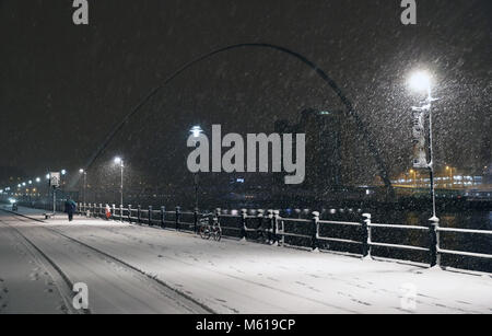 Une personne marche par Newcastle Quayside après de fortes chutes de neige pendant la nuit qui a causé l'interruption en Grande-Bretagne. Banque D'Images