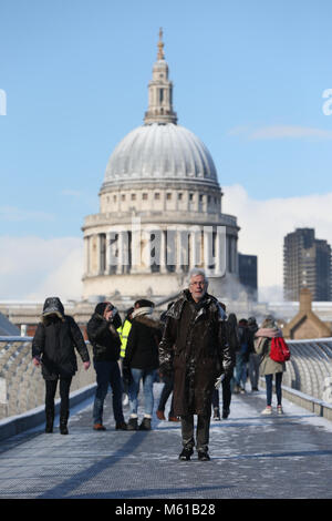 Les gens marcher sur un harfang Millennium Bridge, à Londres, que les fortes chutes de neige sur les routes de l'UK mardi matin après plusieurs centimètres a diminué dans certaines régions au cours de la nuit. Banque D'Images