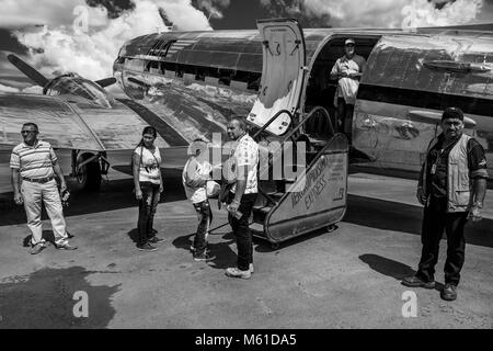 Les passagers à bord d'un Douglas DC-3 à la piste de l'aéroport dans Barranco Minas, la Colombie, le 9 décembre 2016. Bien que la plupart des avions DC-3 de la série ont été construit en 1940, aujourd'hui, presque 80 ans après, certains d'entre eux continuent à voler dans un service quotidien, traversant les savanes et les jungles sans fin dans le dans le sud-est de la Colombie. Le transport de personnes, de l'épicerie, de l'élevage, ou même de petits véhicules, un avion américain légendaire est parfois le seul lien entre les villages de la jungle et le reste du monde. Le DC-3 louange pilotes l'avion pour sa simplicité, reliabi Banque D'Images