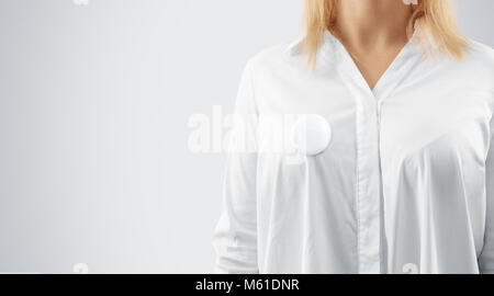 Bouton blanc insigne épinglé sur la maquette de la poitrine de femme, vue en gros plan. Girl porter une chemise blanche et des maquettes de l'axe de la campagne. La conception de l'emblème ronde bénévoles ele Banque D'Images