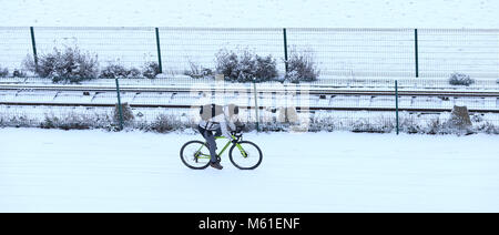 Les cycles d'un homme le long front de mer de Brighton ce matin après une nuit de gel et de neige. 27 févr. 2018 Banque D'Images