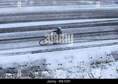 Les cycles d'une femme le long front de mer de Brighton ce matin après une nuit de gel et de neige. 27 févr. 2018 Banque D'Images