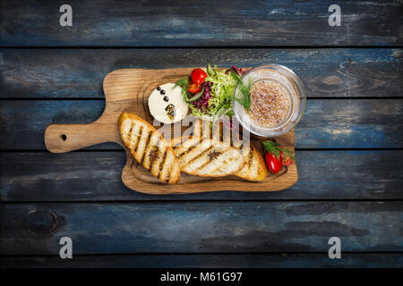 Pain grillé avec du beurre et du caviar sur un fond de bois Banque D'Images