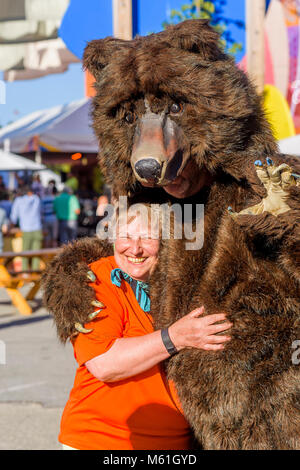 Mortal Coil artiste itinérant en costume d'ours interagit avec femme, Larwill Park, Vancouver, Colombie-Britannique, Canada. Banque D'Images