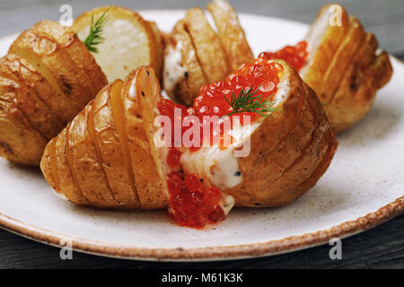 Pomme de terre au four avec sauce hollandaise et caviar rouge dans une assiette, close-up Banque D'Images