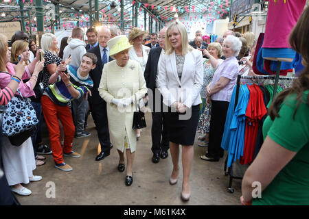 Un jeune homme de faire un trys avec selfies Britain's La reine Elizabeth II comme elle tours Marché St Georges à Belfast, le mardi 24 juin 2014. La Reine est sur une 3 journée de visite de l'Irlande du Nord. Piscine Photo/Paul McErlane Banque D'Images