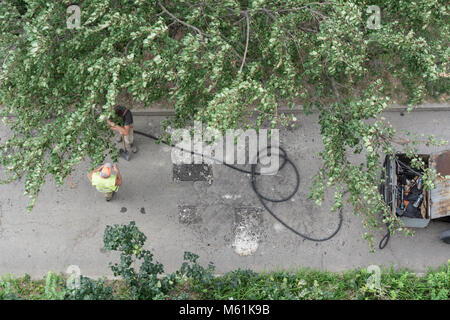 La réparation des routes. Les travailleurs sont la réparation de l'asphalte dans la cour, vue d'en haut. Banque D'Images