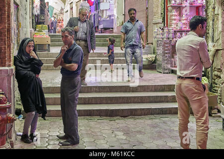 Kashan, Iran - avril 25, 2017 : l'homme iranien parle avec une femme en hijab à côté de l'entrée pour le marché de l'Est. Banque D'Images