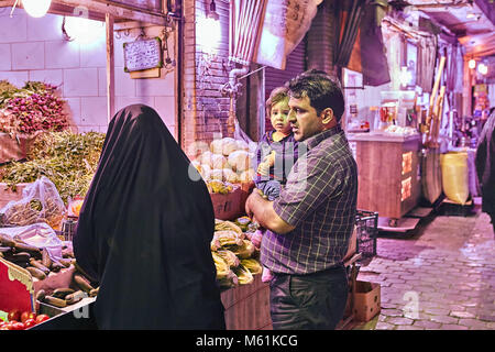 Kashan, Iran - avril 25, 2017 : la famille iranienne légumes achète à un vendeur de rue sur le marché de l'est dans la soirée. Banque D'Images