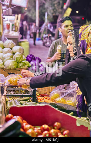 Kashan, Iran - avril 25, 2017 : femme iranienne en hijab achète des légumes dans le marché de la ville sur la rue le soir. Banque D'Images