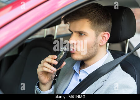 Close-up d'un jeune homme assis à l'intérieur car la prise d'alcool Test Banque D'Images