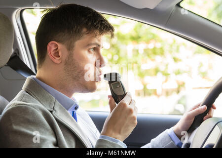 Close-up d'un jeune homme assis à l'intérieur car la prise d'alcool Test Banque D'Images