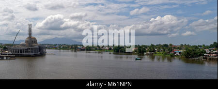 La nouvelle mosquée de remplacement du Masjid Bandar Kuching, en construction, en face d'un Kampong Malais sur la rivière Sarawak Banque D'Images