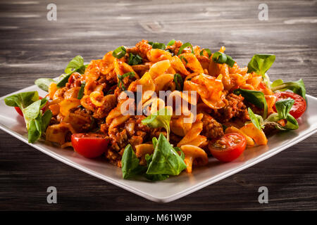 Des pâtes avec sauce tomate sur table en bois Banque D'Images