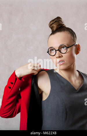 Jeune femme de race blanche entre 30 et 40 ans habillée d'une robe grise. Libre Banque D'Images