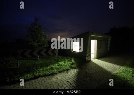 Abri bus lumineux sur le côté du pays dans la nuit. Carzig, Brandebourg, Allemagne, Europe. Banque D'Images