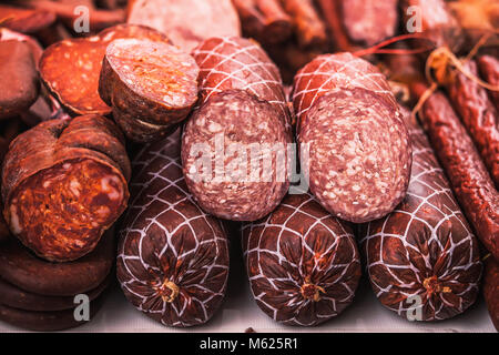 De délicieux morceaux de saucisse fumée exposés à la vente sur le marché. Focus sélectif et petite profondeur de champ Banque D'Images