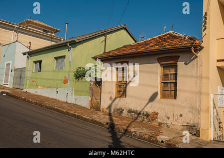 São Manuel, le sud-est du Brésil. Les maisons de couleur minable dans une rue vide sur une journée ensoleillée à São Manuel. Un mignon petit campagne ville. Banque D'Images