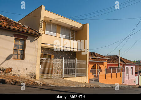 São Manuel, le sud-est du Brésil. Maisons colorées de la classe ouvrière et des clôtures dans une rue vide sur une journée ensoleillée à São Manuel. Un mignon petit campagne ville. Banque D'Images