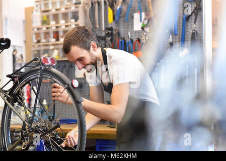 Mécanicien vélo sympa et compétent dans un atelier de réparation de vélo Banque D'Images