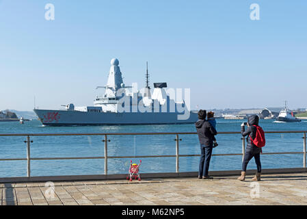 Plymouth, Devon, Angleterre, Royaume-Uni. Le HMS Dragon un type 45 destroyer de défense aérienne de classe audacieuse au départ de Devonport. Vu par un jeune familey. Février 2018 Banque D'Images