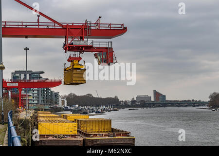 Grue de manutention de conteneurs à déchets Western Riverside près de l'autorité du pont de Wandsworth, les lieux d'un conteneur de déchets domestiques dans une péniche sur la Tamise Banque D'Images