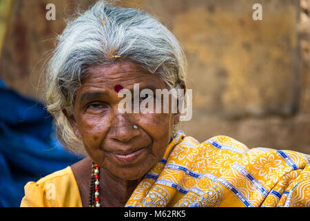 Portrait de Dame avec un aîné indien bindi traditionnel comme un troisième œil, piercing sur le nez et vêtu d'un sari jaune à Mysore, Karnataka, Inde Banque D'Images