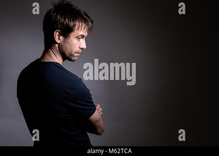 Jeune homme de race blanche avec dos à la caméra à la recherche vers le bas avec l'expression réfléchie Banque D'Images