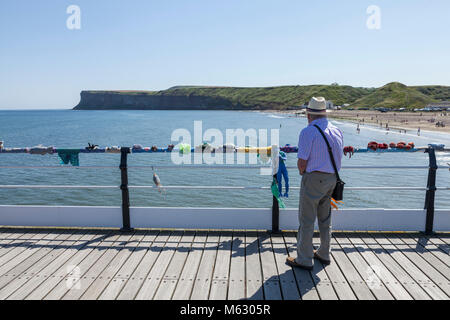 Un homme mûr dans un chapeau de paille donne sur la mer de la jetée à Nice par la mer,Angleterre,UK Banque D'Images