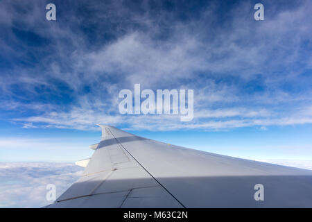 L'aile d'un Boeing 777 avec un ciel nuageux ciel bleu en arrière-plan. Banque D'Images