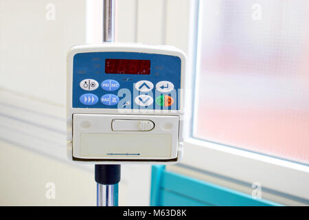 L'alimentation de la pompe à perfusion perfusion IV dans la chambre du patient à l'hôpital sur fond flou. Banque D'Images