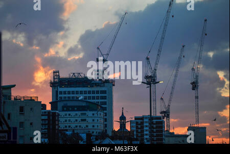 Brighton, UK. 28 Février, 2018. Météo France : Le soleil se lève sur le nouveau Royal Sussex County Hospital travaux de construction à Brighton ce matin après plus de neige sont tombés dans la nuit avec plus de froid prévus pour le reste de la semaine en tant que 'la bête de l'Est" se répand à travers le pays Photo prise par Simon Dack Crédit : Simon Dack/Alamy Live News Banque D'Images