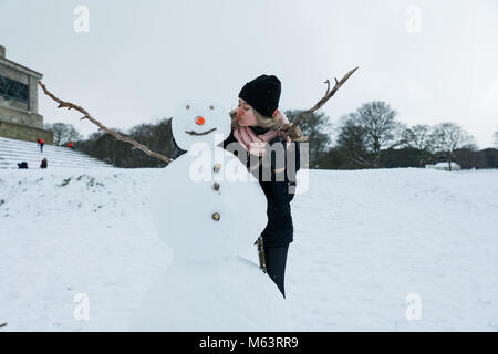 Dublin, Irlande. 28 Février, 2018. Une femme se trouve à côté d'un bonhomme de neige dans le Parc Phoenix à Dublin, Irlande, le 28 février 2018. Une tempête a frappé la plupart des régions de l'Irlande au mercredi, qui a été signalé la pire tempête en Irlande depuis 1982. Source : Xinhua/Alamy Live News Banque D'Images