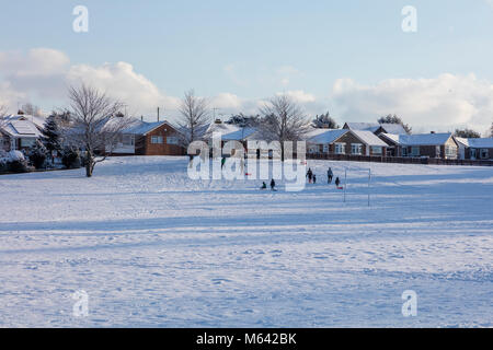 Herne, Kent, UK, 28 février 2018. Météo UK News:Après une forte chute de neige dans la région de Canterbury East Ken ,du jour au lendemain. Le soleil apparaît dans le village de Herne à mesure que la circulation des bus et de lutte sur le A291, les enfants jouent sur les pistes dans leurs luges. Richard Donovan/Alamy Live News Banque D'Images