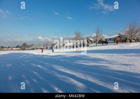 Herne, Kent, UK, 28 février 2018. Météo UK News:Après une forte chute de neige dans la région de Canterbury East Ken ,du jour au lendemain. Le soleil apparaît dans le village de Herne à mesure que la circulation des bus et de lutte sur le A291, les enfants jouent sur les pistes dans leurs luges. Richard Donovan/Alamy Live News Banque D'Images