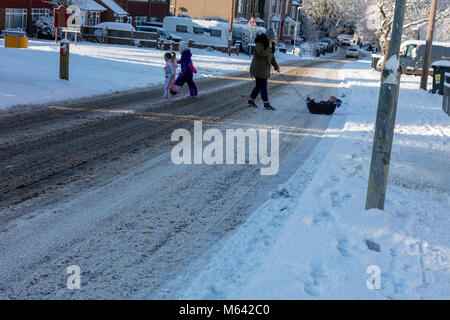 Herne, Kent, UK, 28 février 2018. Météo UK News:Après une forte chute de neige dans la région de Canterbury East Ken ,du jour au lendemain. Le soleil apparaît dans le village de Herne à mesure que la circulation des bus et de lutte sur le A291, les enfants jouent sur les pistes dans leurs luges. Richard Donovan/Alamy Live News Banque D'Images