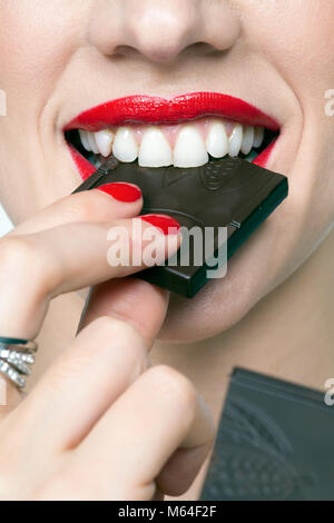 Close up de bouche de femme avec chocolat noir Banque D'Images