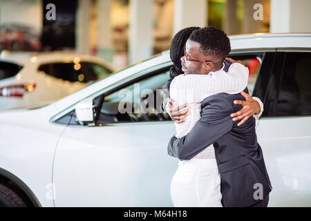 La collecte de couple nouvelle voiture de vendeur sur le lot Banque D'Images