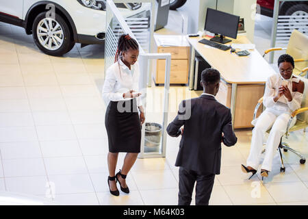 Vendeur de voiture chez le concessionnaire permanent qui dispose de voiture pour les clients Banque D'Images