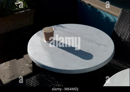 Vide la tasse de café à emporter sur table, long shadow Banque D'Images