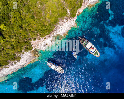 Les gens de nager dans les eaux bleues de l'Île, près de Corfou Antipaxos - Kerkira, Grèce. Vue aérienne d'un voyage en bateau pour la petite île de Gaio Banque D'Images