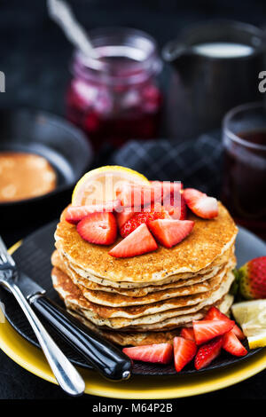 Pile de citron fraîchement préparé des crêpes aux graines de pavot avec des fraises fraîches et du sirop pour le petit déjeuner Banque D'Images