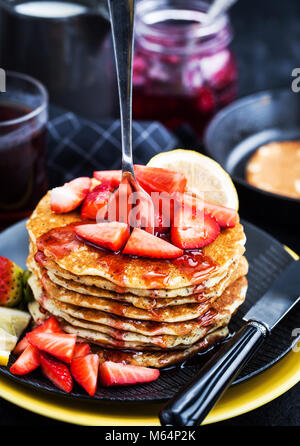 Pile de citron fraîchement préparé des crêpes aux graines de pavot avec des fraises fraîches et du sirop pour le petit déjeuner Banque D'Images