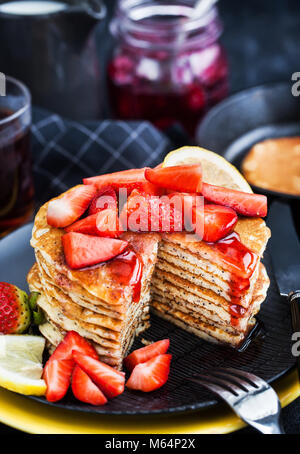 Pile de citron fraîchement préparé des crêpes aux graines de pavot avec des fraises fraîches et du sirop pour le petit déjeuner Banque D'Images